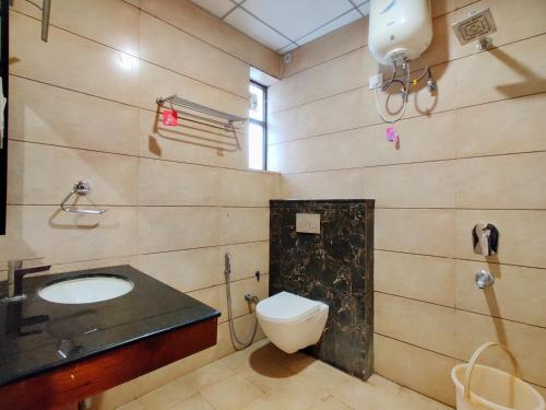 a bathroom with a toilet and a sink at Hotel Divine Residency by VARSHRI in Haridwār
