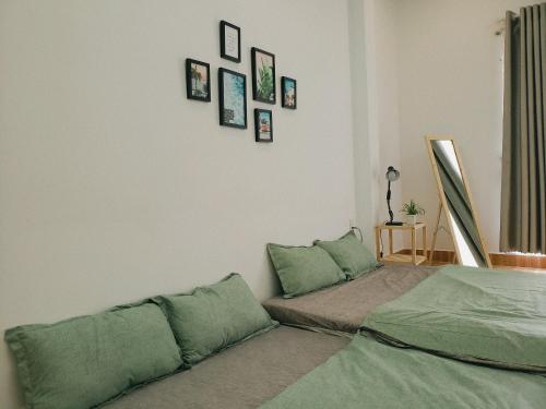 een slaapkamer met een bed en wat foto's aan de muur bij One Room in Vung Tau