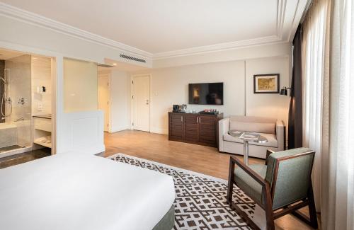 a bedroom with a bed and a chair and a couch at The Stay Boulevard Nisantasi in Istanbul