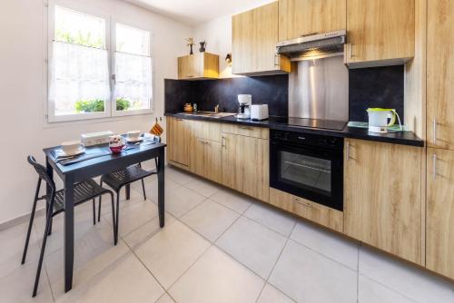 une cuisine avec des armoires en bois et une table avec des chaises dans l'établissement La Fermette, à Andeville