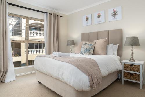 a bedroom with a large bed and a window at Formosa luxury apartment in Cape Town