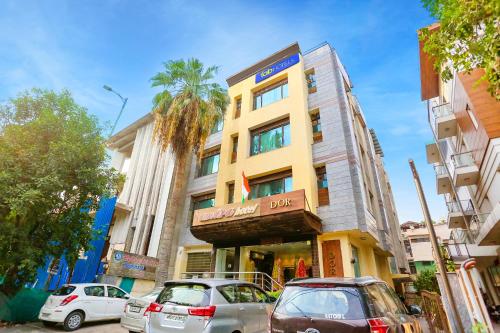 un edificio con coches estacionados frente a él en FabHotel Heaven In, en Nueva Delhi