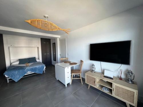 sala de estar con cama y TV de pantalla plana en *Blue Sea Studio Altea * At the beach, en Altea