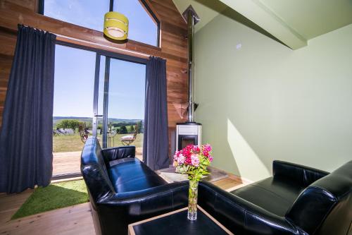 a living room with a couch and a vase of flowers on a table at Tarset Tor - Bothy 2 in Hexham