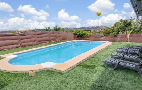 a swimming pool with two lawn chairs next to it at Stunning Home In Arcos De La Frontera in Arcos de la Frontera
