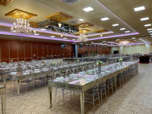 a large banquet hall with long tables and chandeliers at Awangan Palace in Kuantan