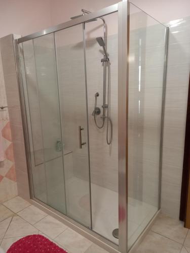 W łazience znajduje się prysznic ze szklanymi drzwiami. w obiekcie Casa Blu oltremare w mieście SantʼAntìoco