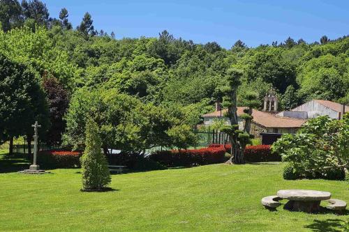 a park with a stone bench in the grass at Pazo de Eidian in Eidián