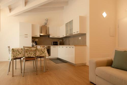 a kitchen and living room with a table and a couch at HOLIDAY APARTMENTS GIULIA - Green in Pietramurata