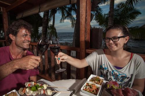 a man and woman sitting at a table with a glass of wine at Parrot Cove Lodge in Hopkins