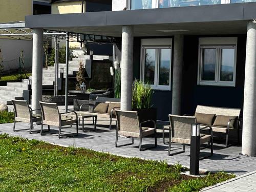 eine Gruppe von Stühlen und Tischen auf einer Terrasse in der Unterkunft Ferienwohnung BodenseeSuite in Friedrichshafen in Friedrichshafen