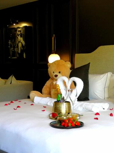 a teddy bear sitting on top of a bed with hearts at Seven Villa Hotel & Spa in Johannesburg