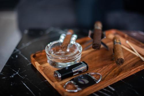 a wooden cutting board with a glass jar and some cigars at Seven Villa Hotel & Spa in Johannesburg