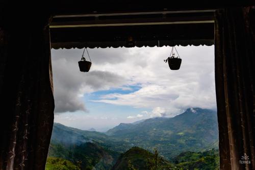 a window with two hanging baskets in the mountains at TeHyCa in Kūkkāl