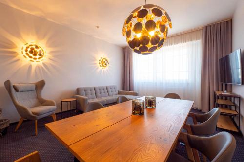 a living room with a wooden table and chairs at Centrum Hotel Viljandi in Viljandi