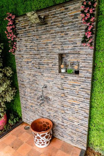 a brick wall with a water fountain in a garden at TeHyCa in Kūkkāl