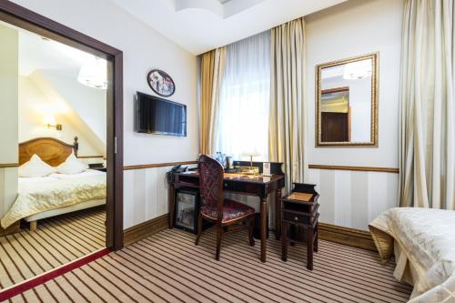 a hotel room with a desk and a bed at Hotel St. Bruno in Giżycko