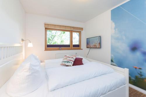 een wit bed in een kamer met een raam bij Nienhagen in Nienhagen