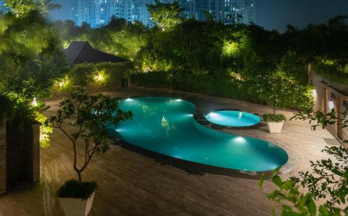 einen Blick über den Pool in der Nacht in der Unterkunft NAAD WELLNESS in Sonīpat