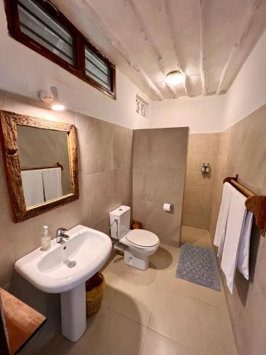 a bathroom with a sink and a toilet and a mirror at White Dream in Kiwengwa