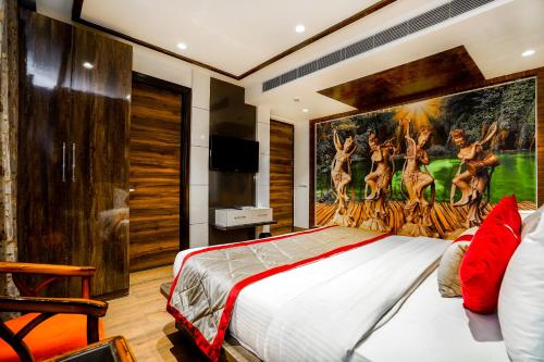 Schlafzimmer mit einem Bett mit Wandgemälde in der Unterkunft Amritsar Grand By Levelup Hotels 100 meters from golden temple in Amritsar