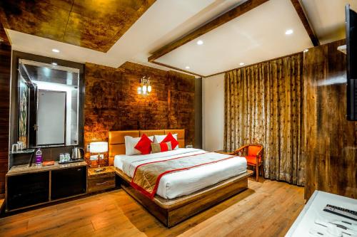 ein Hotelzimmer mit einem Bett und einem Spiegel in der Unterkunft Amritsar Grand By Levelup Hotels 100 meters from golden temple in Amritsar