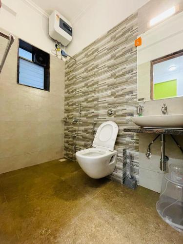 een badkamer met een toilet en een wastafel bij White Tulip in Lonavala