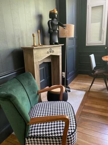 a living room with a chair and a fireplace at Le Clos maison 3 chambres avec extérieur et parking Epernay centre in Épernay