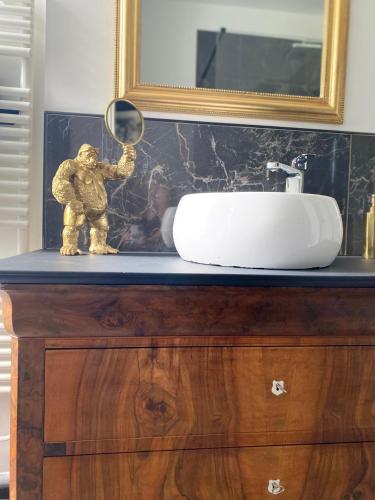 a bathroom with a sink and a mirror on a dresser at Le Clos maison 3 chambres avec extérieur et parking Epernay centre in Épernay