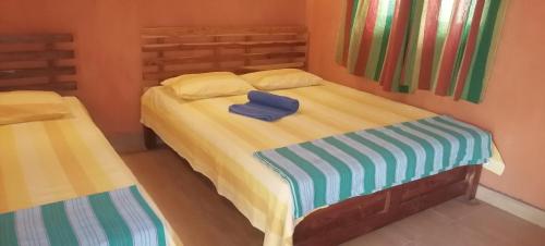 a bedroom with a bed with a blue pillow on it at කැලෑව Kelewa Eco Resort in Anuradhapura