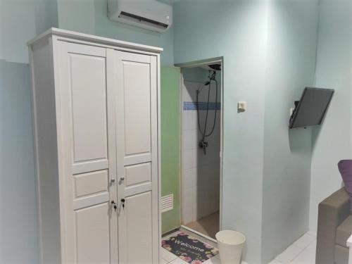 een badkamer met een witte kast en een douche bij Susilo Residence 10 in Jakarta