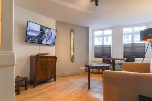 a living room with a flat screen tv on the wall at Apartments im Einhornhaus in Lübeck