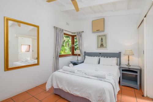 ein Schlafzimmer mit einem großen Bett und einem Spiegel in der Unterkunft San Lameer Villa 2408 - 2 Bedroom Classic - 4 pax - San Lameer Rental Agency in Southbroom