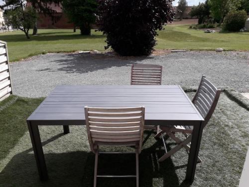 a wooden table with two chairs sitting around it at gîte de Courcelette in Courcelette