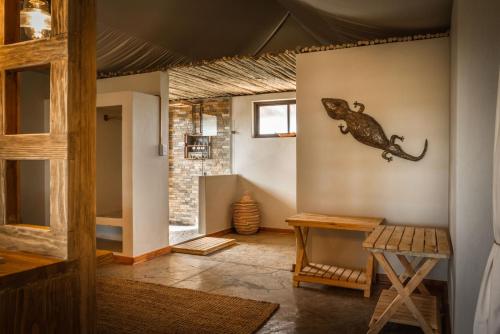 a living room with a lizard on the wall at Imagine Africa Luxury Tented Camp in Balule Game Reserve