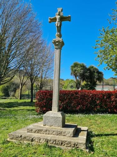 a cross on a pedestal in a park at Pazo de Eidian in Eidián