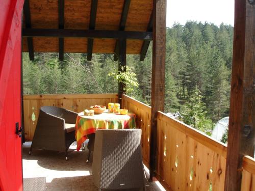 a table and chairs on a porch with a view at Zeleni Čardaci etno apartmani in Kaludjerske Bare