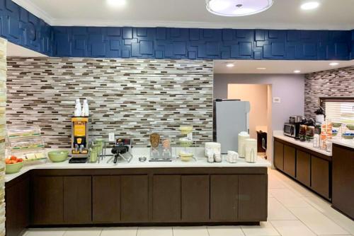 una grande cucina con un bancone e un muro di mattoni blu di Quality Inn Albany ad Albany