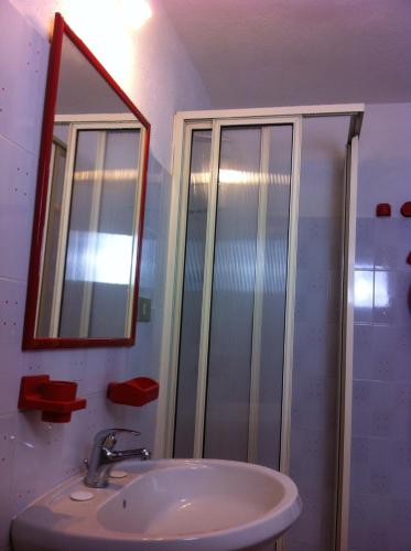 a bathroom with a sink and a shower with a mirror at Casa Jacopo in Torre delle Stelle