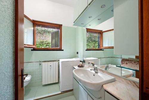 a bathroom with a sink and a toilet and a mirror at Arenzano pineta in Arenzano