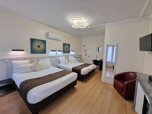 une chambre d'hôtel avec deux lits et une chaise dans l'établissement Hôtel Océanic - Grands Magasins, à Paris