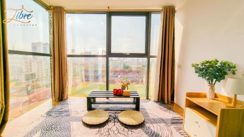 Libré Homestay في هانوي: غرفة معيشة مع طاولة ونافذة كبيرة