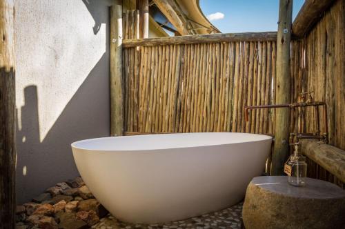 a white bath tub sitting in a bathroom at Imagine Africa Luxury Tented Camp in Balule Game Reserve
