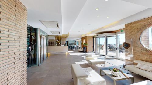 a lobby with white furniture and a brick wall at Smy Aran Blu Roma Mare in Lido di Ostia