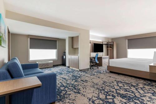 a hotel room with a bed and a couch at Comfort Inn & Suites in Muskogee