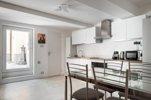 a kitchen with white cabinets and a table with chairs at Il giardino segreto di Orfeo by Wonderful Italy in Bologna