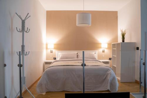 a bedroom with a white bed with two lights on at Living Room Schiavonea in Schiavonea