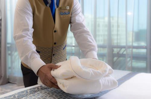 a man is holding a roll of towels at MADEN Hotel in Al Madinah