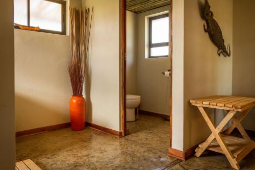 a bathroom with an orange vase and a toilet at Imagine Africa Luxury Tented Camp in Balule Game Reserve