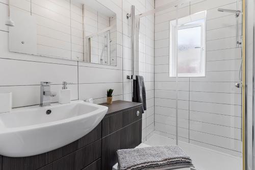 a white bathroom with a sink and a shower at Church View by Staytor Accommodation in Exeter